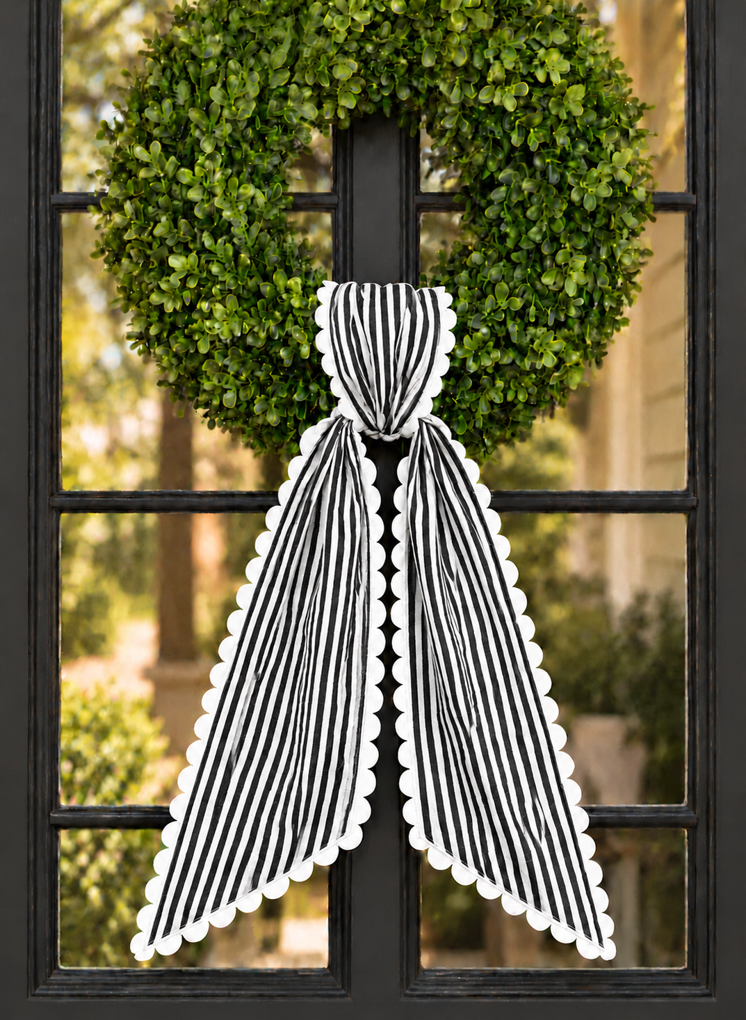 Black stripe wreath sash with white scalloped ric rac trim, embroidery blank on a boxwood wreath
