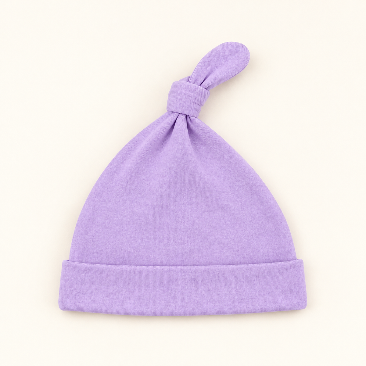 A Lilac Knot baby hat with a folded cuff and a knotted top, shown on a plain off-white background.