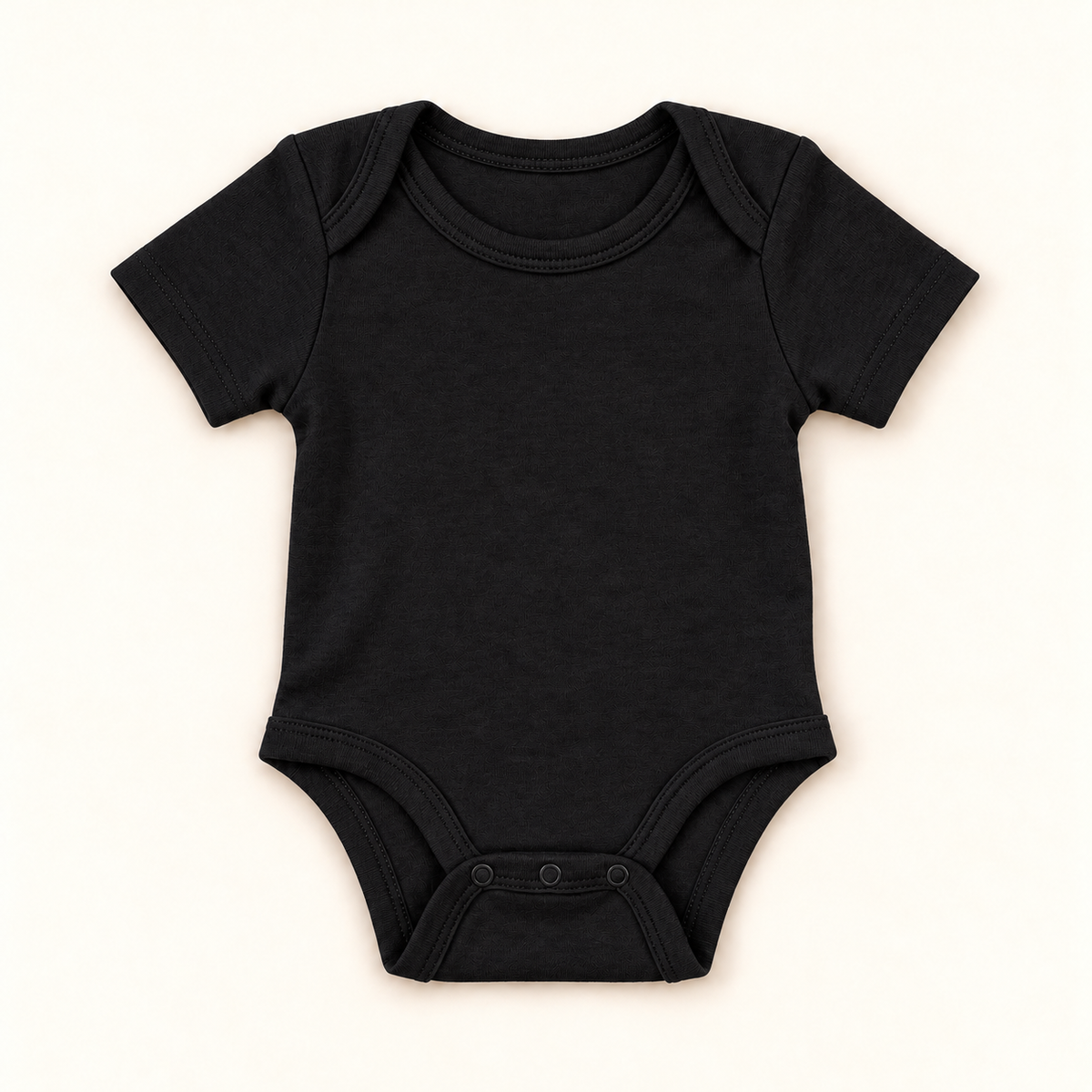 A black short-sleeve baby bodysuit with three-button crotch closure, laid flat on a light cream background.